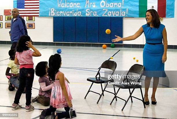 Mexican first lady Margarita Zavala throws a ball to second graders during a physical education class as she visits New Hampshire Estates Elementary...