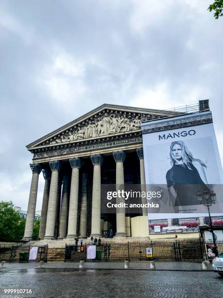 la madeleine church avec publicité énorme mangue, paris, france - quartier de la madeleine photos et images de collection