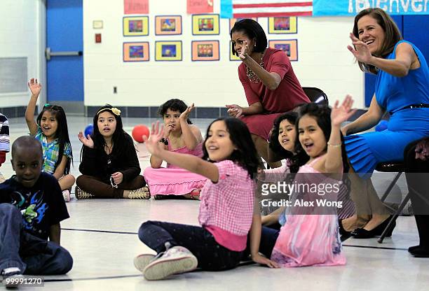First lady Michelle Obama and her Mexican counterpart Margarita Zavala wave with second graders during a physical education class as they visit New...