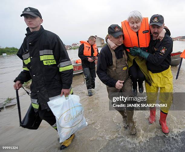 Rescue team members evacuate an elderly woman from the flooded district of Sandomierz, central Poland, on May 19,2010. The floods striking southern...