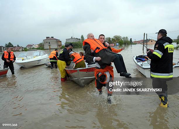 Rescue team members evacuate an elderly man from the flooded district of Sandomierz, central Poland, on May 19,2010. The floods striking southern...