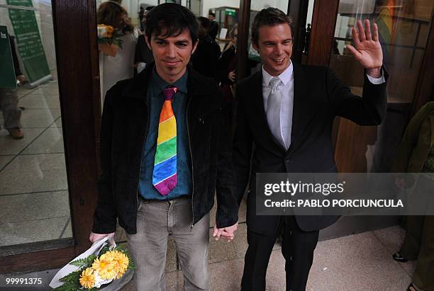 The couple Damian and Gonzalo, members of the Ovejas Negras gays, lesbians and transvestites organization, wave to friends after enacted marriages at...