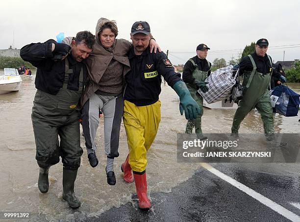 Rescue team members evacuate an elderly woman with her belongings from the flooded district of Sandomierz, central Poland, on May 19,2010. The floods...