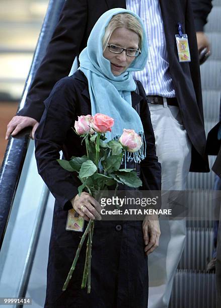 Swiss ambassador to Iran Livia Leu Agosti holds roses as she arrives to greet the mothers of detained US hikers at the Imam Khomeini airport in...
