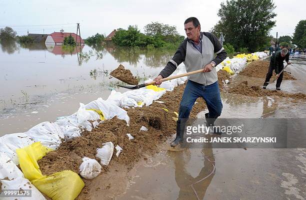 Men set up a fence with sandbags in the flooded district of Sandomierz, central Poland, on May 19, 2010. The floods striking southern Poland could...