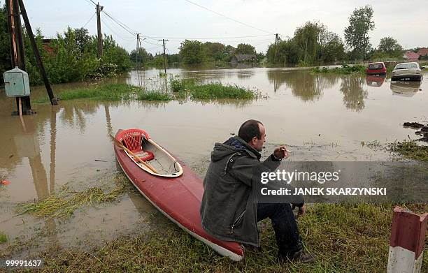 Local resident sits on a canooe on the river bank in the flooded district of Sandomierz, central Poland, on May 19,2010. The floods striking southern...