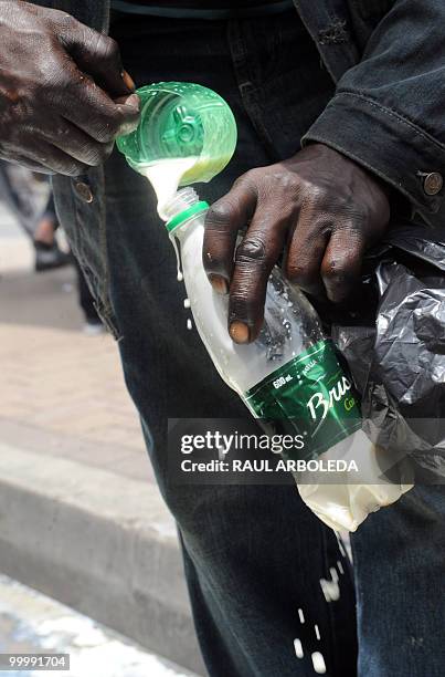 Man drinks milk spilled on the ground after dairy farmers distributed free milk during a demonstration on May 19, 2010 in Medellin, Antioquia...