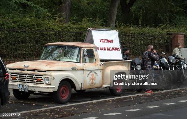 Pick-up truck with a sign reading 'Freedom is our Religion' can be seen next to motor cyclists preparing for a demonstration on Alt-Biesdorf street...