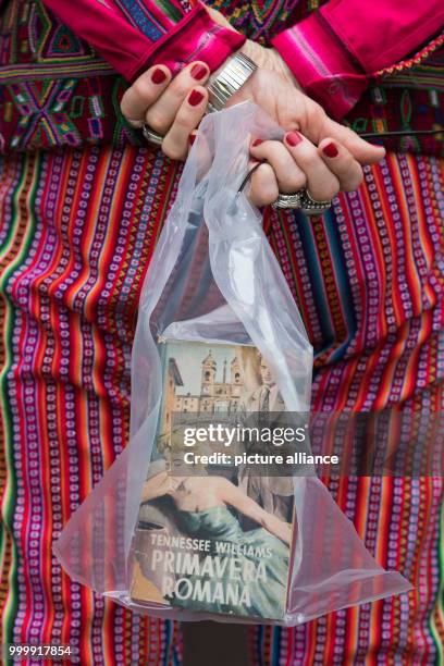 Argentinian artist Marta Minujin holds a copy of Tennessee Williams 'Primavera Romana', the Italian translation of the 'The Roman Spring of Mrs....