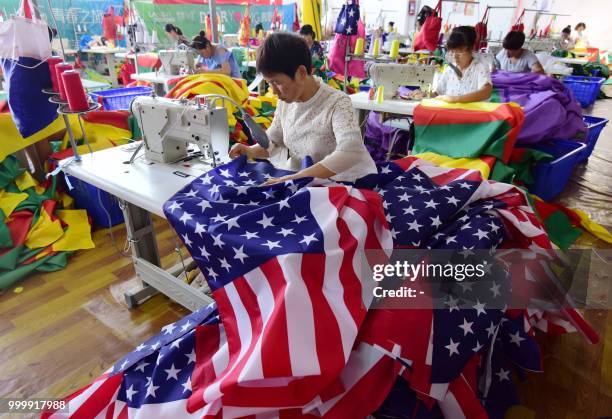 This photo taken on July 13, 2018 shows Chinese employees sewing US flags at a factory in Fuyang in China's eastern Anhui province. - As the Sino-US...
