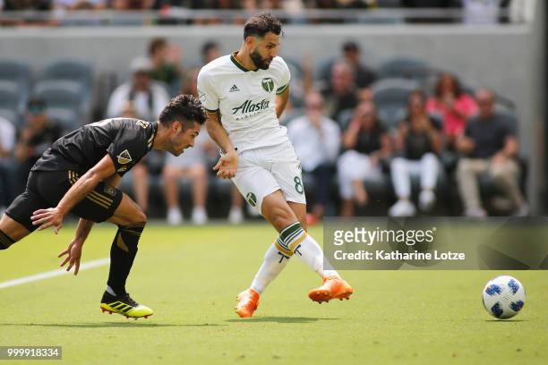 Diego Valeri of the Portland Timbers takes a shot on goal trailed by Benny Feilhaber of the Los Angeles Football Club at Banc of California Stadium...