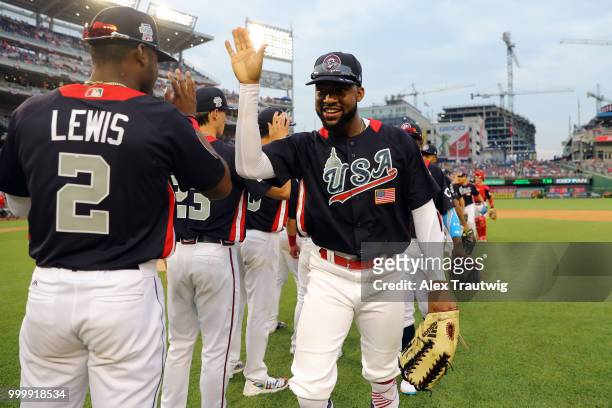Jo Adell of Team USA celebrates with teammates after Team USA defeated the World Team in the SiriusXM All-Star Futures Game at Nationals Park on...
