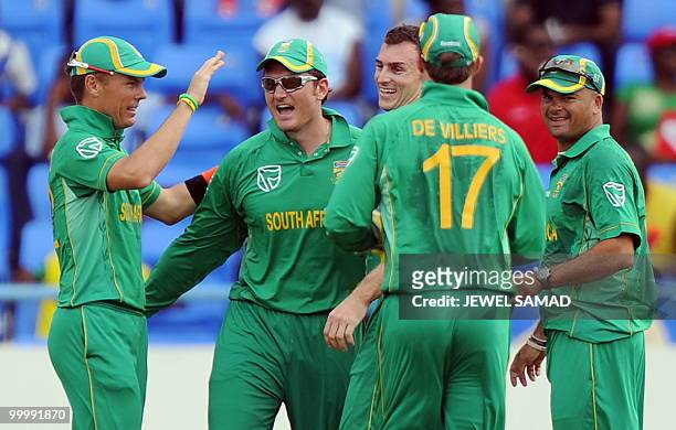 South African cricket team captain Graeme Smith celebrates with teammates after taking a catch to dismiss his West Indies counterpart Chris Gayle...