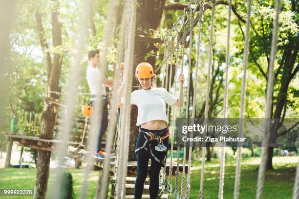 beautiful young woman walking over a hanging bridge - ziga plahutar stock pictures, royalty-free photos & images