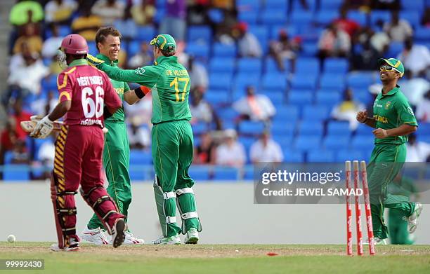 South African wicketkeeper AB de Villiers celebrates with teammates after dismissing West Indies batsman Narsingh Deonarine during the first T20...