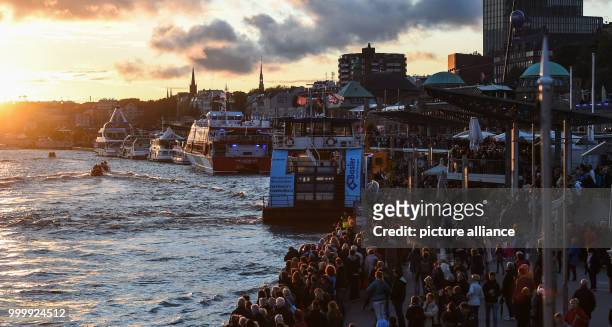 Visitors look at the passing cruise ships during the cruise festival Hamburg Cruise Days at the Elbe river in Hamburg, Germany, 9 September 2017....