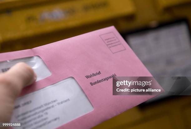 Man throws his documents for the general elections 2017 in an envelope into a mailbox in Munich, Germany, 10 September 2017. Photo: Sven Hoppe/dpa