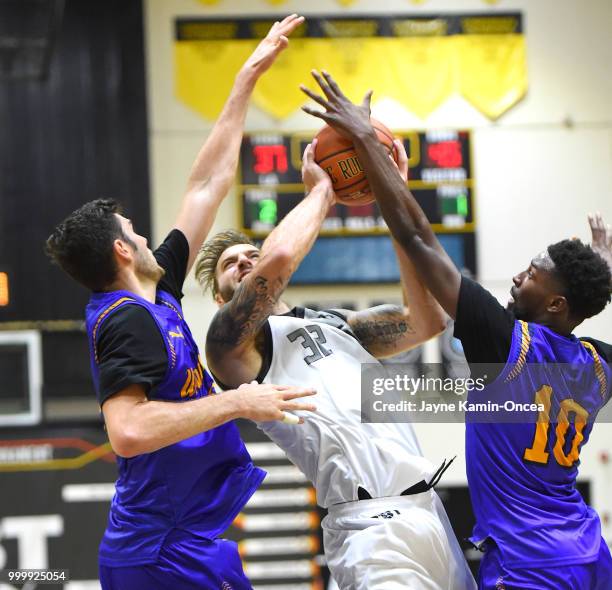 Gyorgy Goldman and Isaac Hamilton of the Sons of Westwood guard Drew Maynard of the Albuquerque Hoops during the Western Regional of The Basketball...