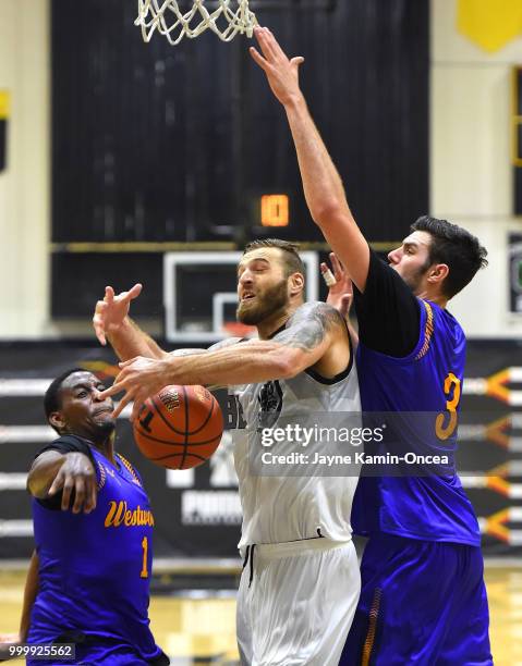 Gyorgy Goldman and Jordan Adams of the Sons of Westwood guard Drew Maynard of the Albuquerque Hoops during the Western Regional of The Basketball...