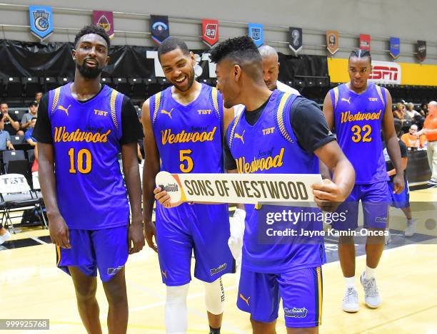 Isaac Hamilton and Khalif Wyatt walk with Jerrold Smith of the Sons of Westwood to pin their name on the winners bracket board after defeating the...