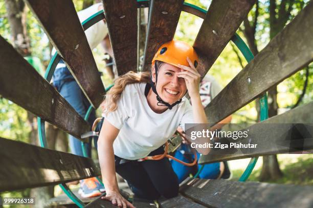 adventurous woman climbing in a wooden tunnel - ziga plahutar stock pictures, royalty-free photos & images