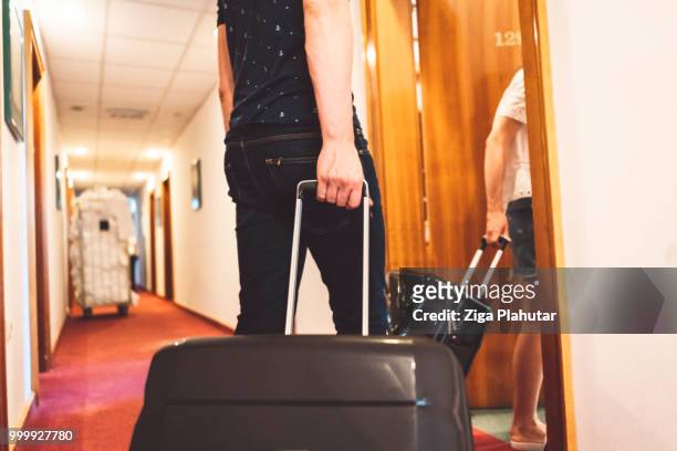young couple walking into their hotel room - ziga plahutar stock pictures, royalty-free photos & images