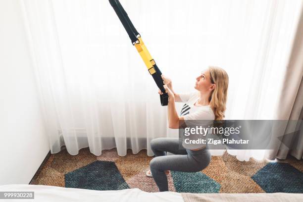 young active woman working out with trx - ziga plahutar stock pictures, royalty-free photos & images