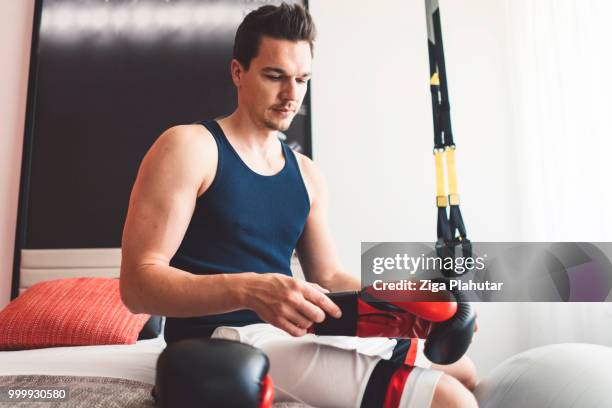 young active men putting on boxing gloves - ziga plahutar stock pictures, royalty-free photos & images