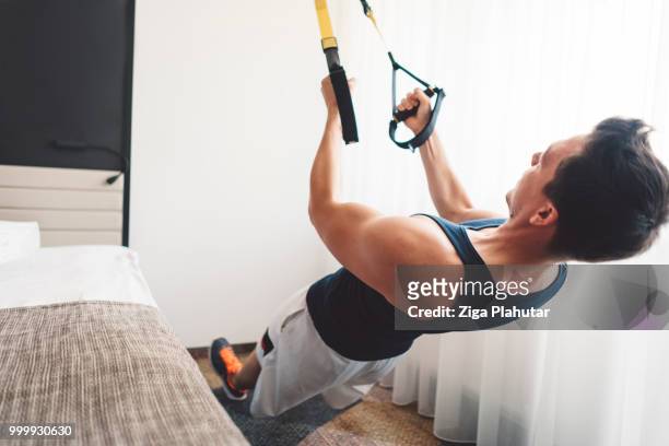 hombre activo joven haciendo ejercicios de trx - ziga plahutar fotografías e imágenes de stock