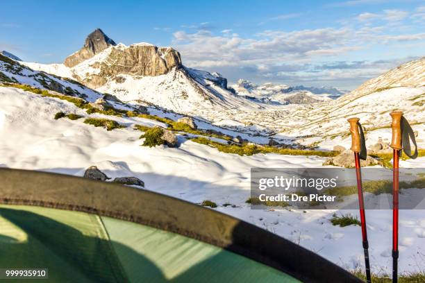 tent and hiking sticks in snowy mountain landscape. trekking in swiss alps. hoch turm, charetalp,... - turm stock pictures, royalty-free photos & images