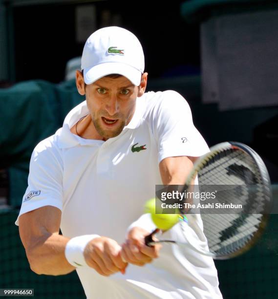 Novak Djokovic of Serbia plays a backhand against Kevin Anderson of South Africa in the Men's Singles final on day thirteen of the Wimbledon Lawn...