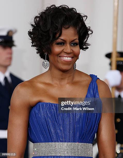 First lady Michelle Obama smiles as she and her husband U.S President Barack Obama wait for Mexican President Felipe Calderon and his wife Margarita...