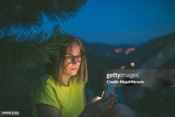 pretty young woman looking off a cliff into valley - mitrovic stock pictures, royalty-free photos & images