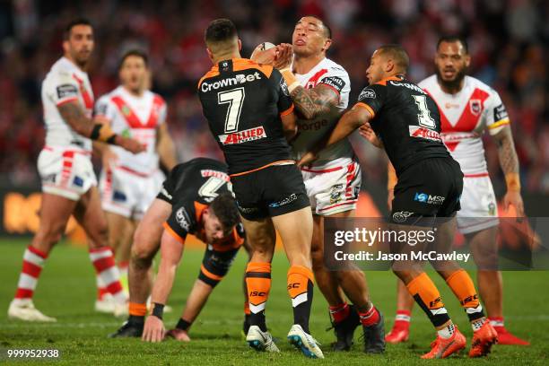 Tyson Frizell of the Dragons is tackled by Luke Brooks and Moses Mbye of the Tigers during the round 18 NRL match between the St George Illawarra...