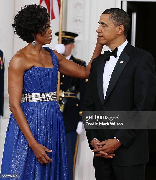 First lady Michelle Obama stands with her husband U.S President Barack Obama as they wait for Mexican President Felipe Calderon and his wife...