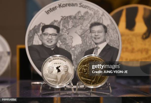 Medallions commemorating the historic inter-Korean summit between Moon Jae-in and Kim Jong Un are displayed during an unveiling ceremony at a sales...