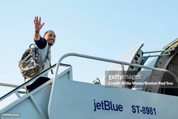 Mookie Betts of the Boston Red Sox waves as he boards the plane during a team charter flight to Washington, DC for the 2018 Major League Baseball...