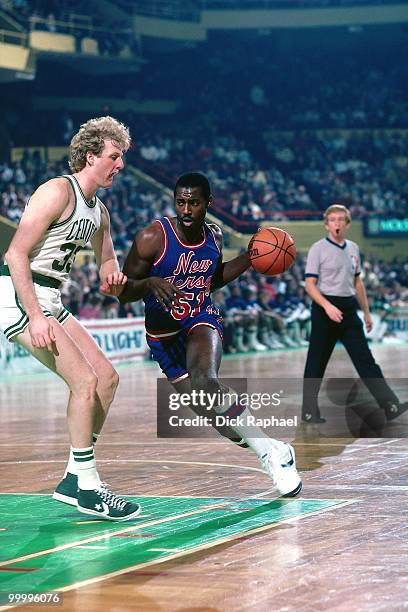 Eddie Phillips of the New Jersey Nets drives to the basket against Larry Bird of the Boston Celtics during a game played in 1983 at the Boston Garden...
