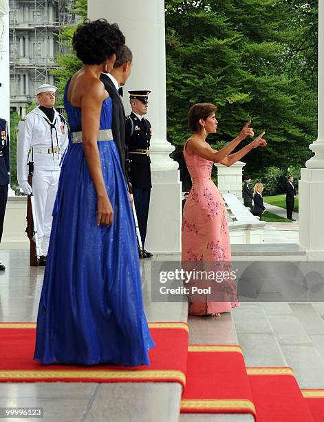 President Barack Obama and first lady Michelle Obama look on as Chief of Protocol of the United States Capricia Penavic Marshall gets up after...