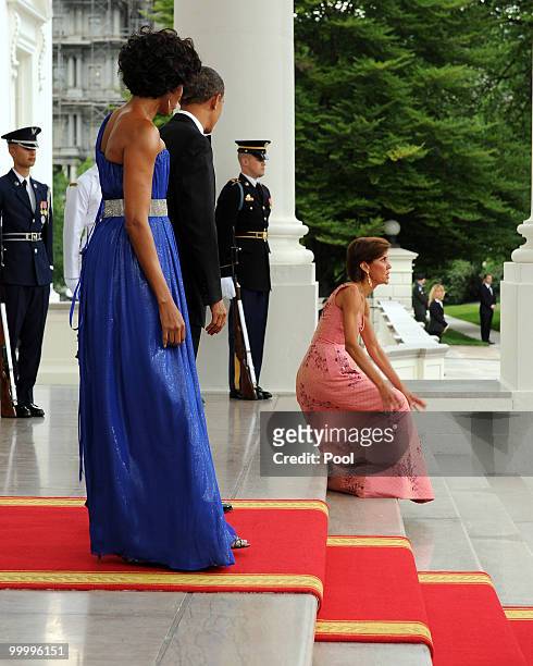 President Barack Obama and first lady Michelle Obama look on as Chief of Protocol of the United States Capricia Penavic Marshall gets up after...