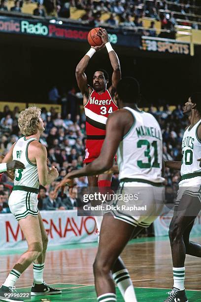 Kenny Carr of the Portland Trail Blazers shoots a jumper over Larry Bird and Cedric Maxwell of the Boston Celtics during a game played in 1983 at the...