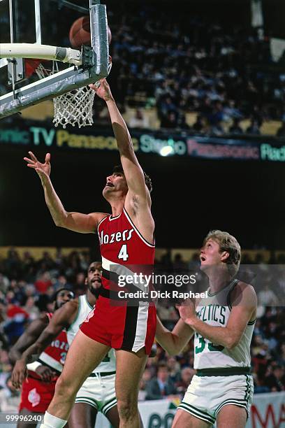 Jim Paxson of the Portland Trail Blazers shoots a layup against Larry Bird of the Boston Celtics during a game played in 1983 at the Boston Garden in...