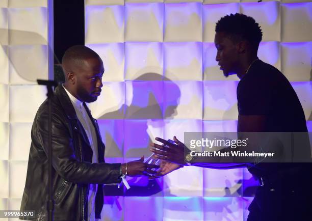 Honoree Victor Oladipo accepts an award onstage from Lamorne Morris during the 33rd Annual Cedars-Sinai Sports Spectacular at The Compound on July...