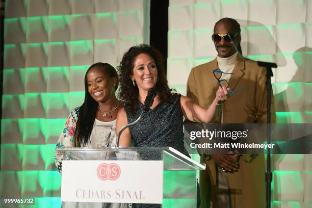 Honoree Constance Schwartz Morini accepts an award from Shante Broadus and Snoop Dogg onstage during the 33rd Annual Cedars-Sinai Sports Spectacular...