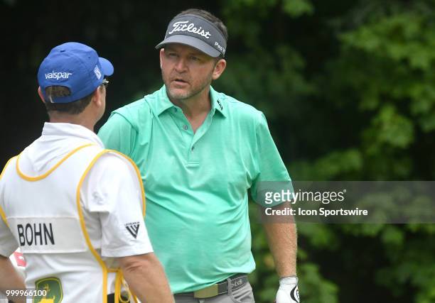 Jason Bohn talks with his caddy before teeing off on the hole during the final round of the John Deere Classic on July 15 at TPC Deere Run, Silvis,...