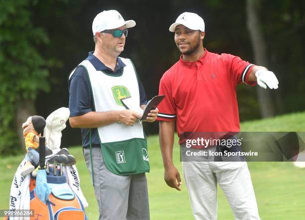 Harold Varner III talks to his caddy about the best way to play his second shot on the hole during the final round of the John Deere Classic on July...