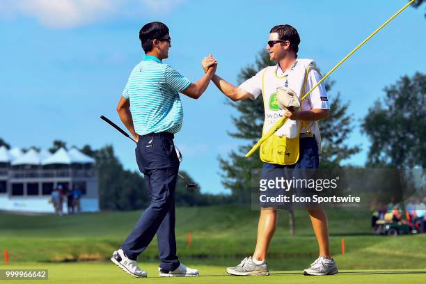 Michael Kim shakes hands with his caddy on the 18th hole after winning the John Deere Classic on July 15, 2018 at the TPC Deere Run in Silvis,...