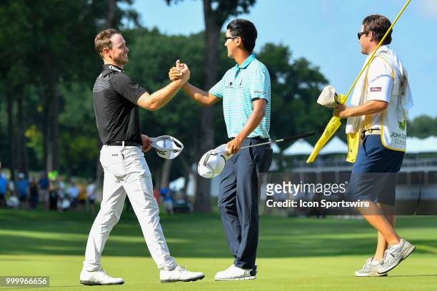 Michael Kim shake hands with Bronson Burgoon on the 18th green after winning the final round of the John Deere Classic on July 15, 2018 at the TPC...
