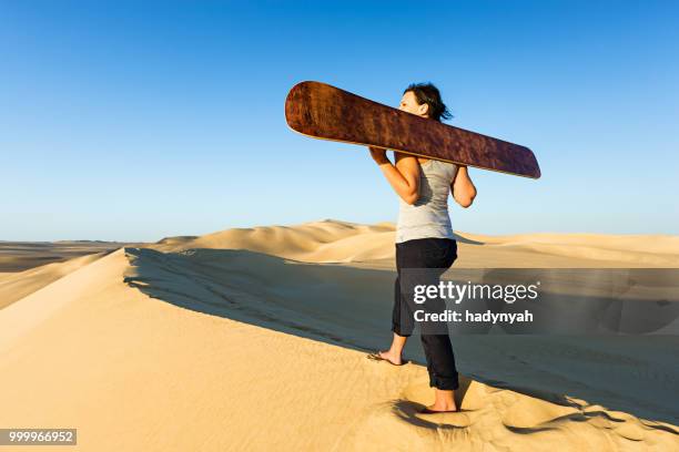 mujer joven sandboarding en el desierto del sahara, áfrica - desierto libio fotografías e imágenes de stock