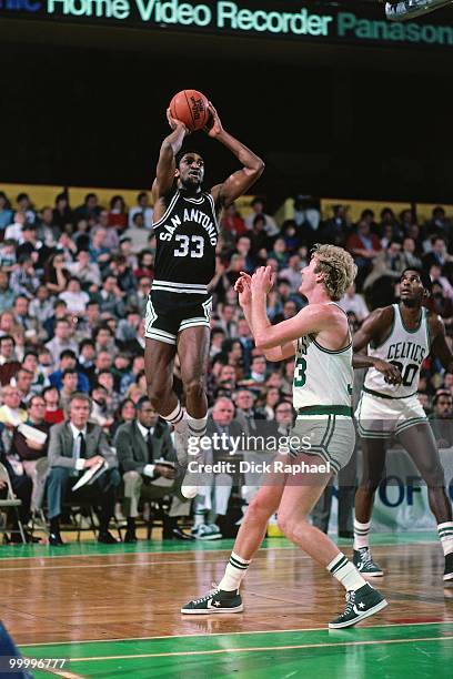 Bill Willoughby of the San Antonio Spurs shoots a jumper against Larry Bird of the Boston Celtics during a game played in 1983 at the Boston Garden...